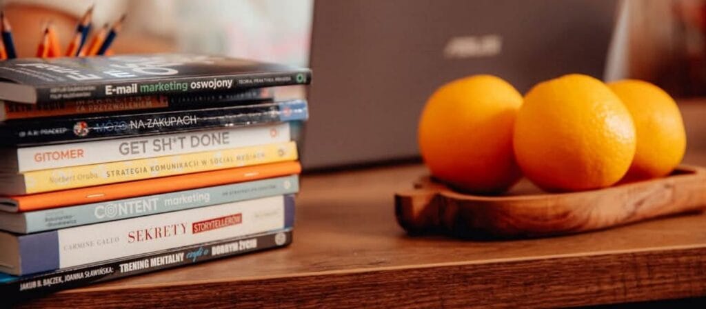 Zdjęcie biurka z książkami i pomarańczą